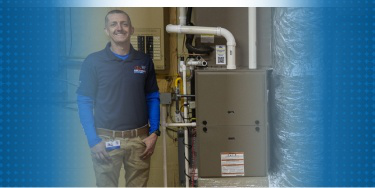 Pipe Wrench Plumbing employee standing next to HVAC system.